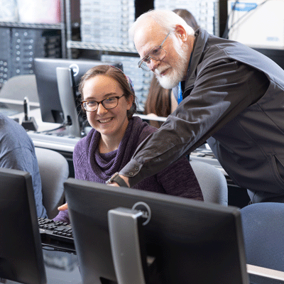 Student and instructor in computer lab.