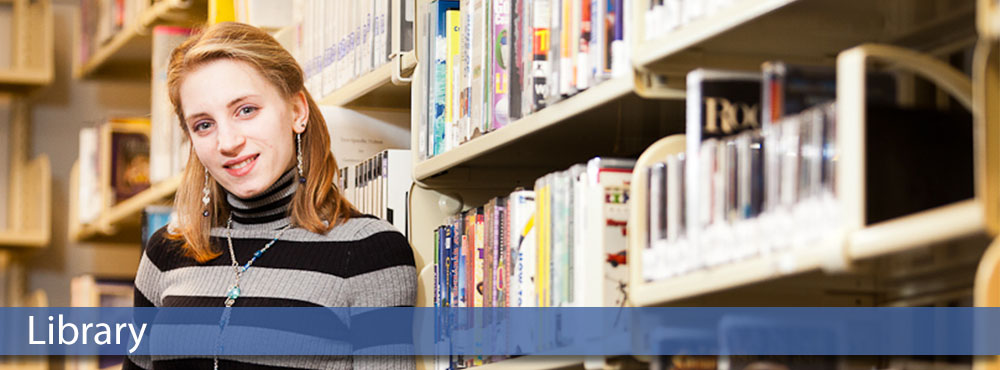 MSC student leaning against library bookshelves